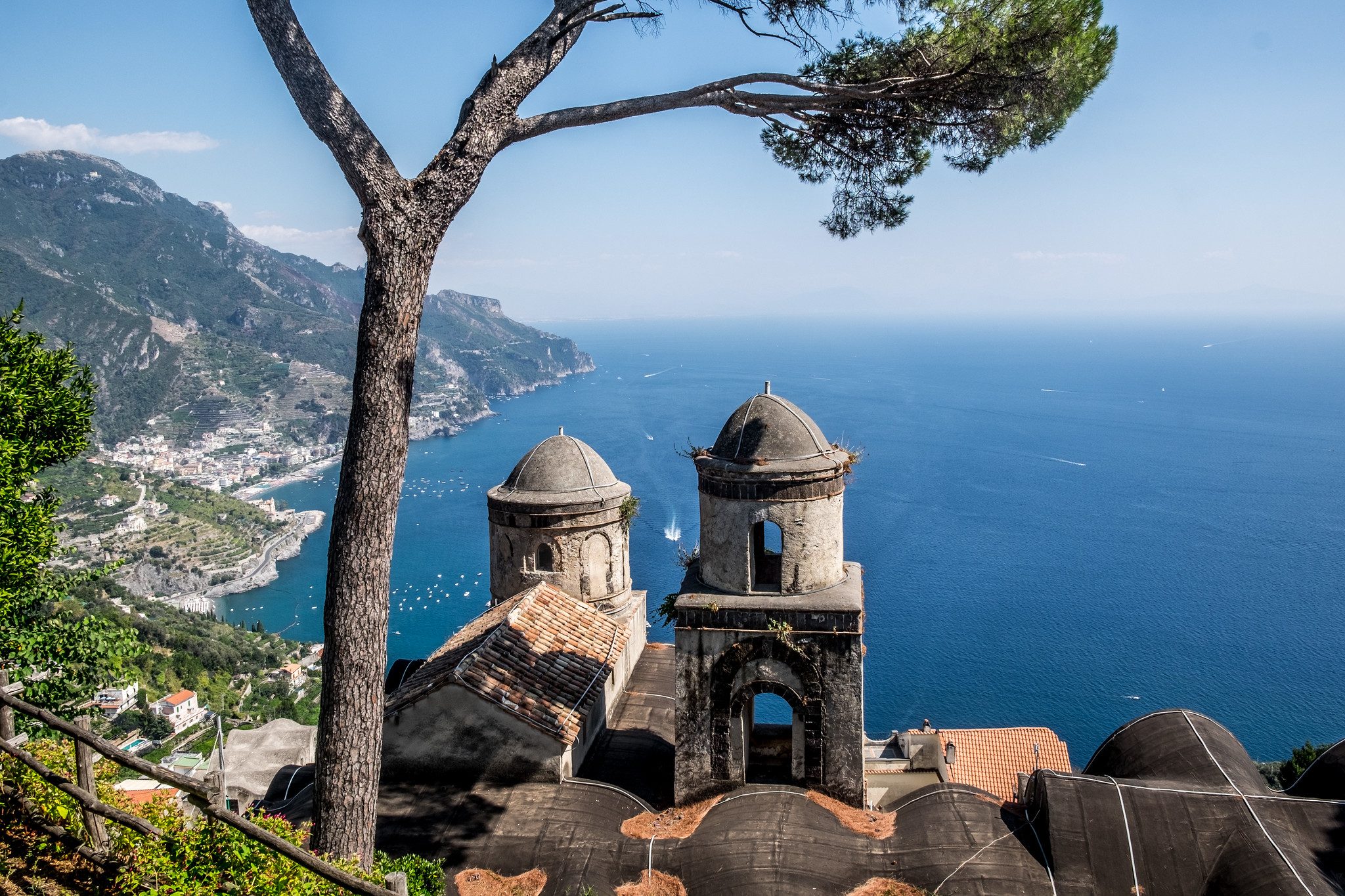 The domed bell towers of Ravello under umbrella pines, with the Amalfi Coast and the sea below